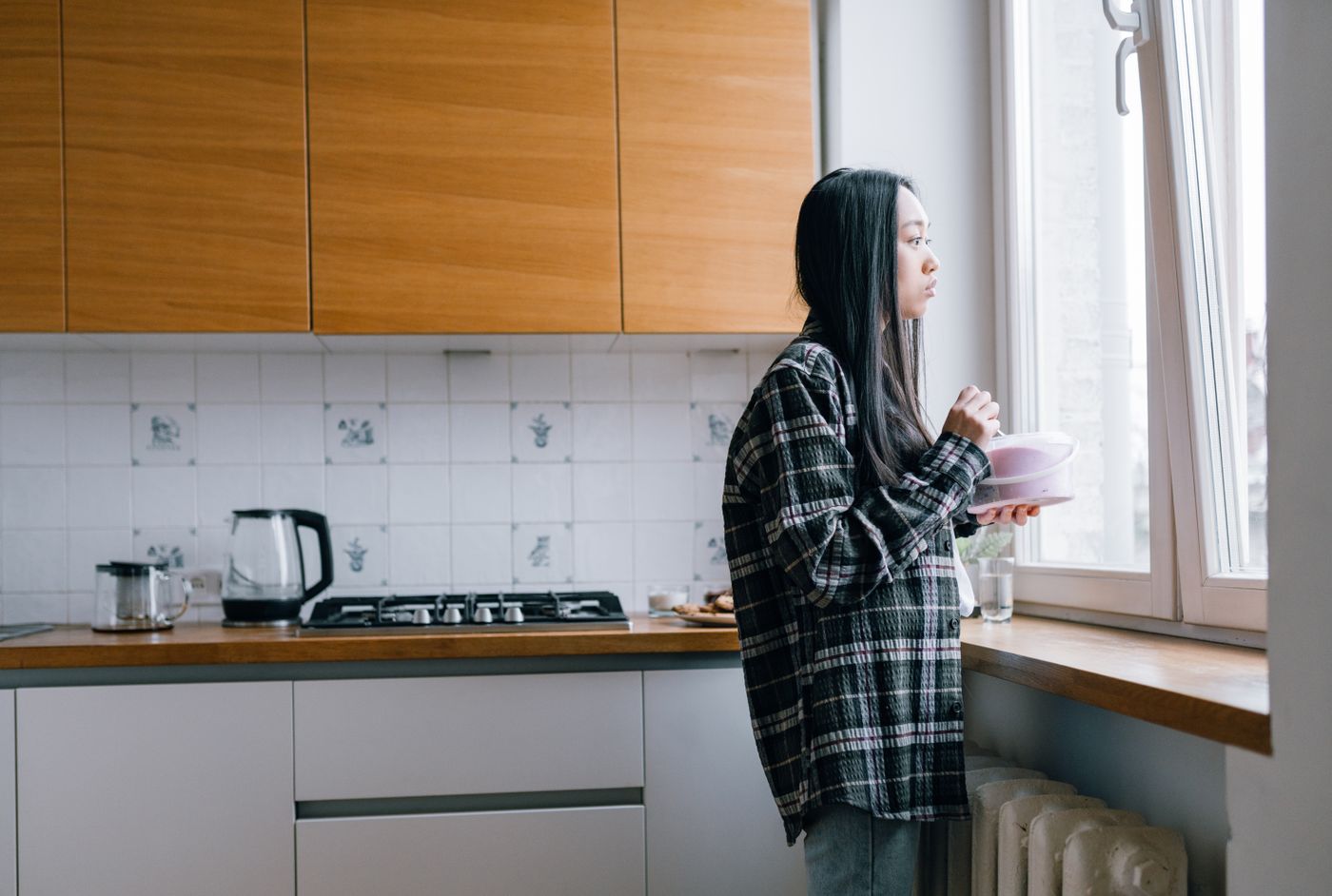 Psicólogo especialista en problemas de alimentación en Vigo Mujer pensativa en la cocina de su casa con una taza en la mano