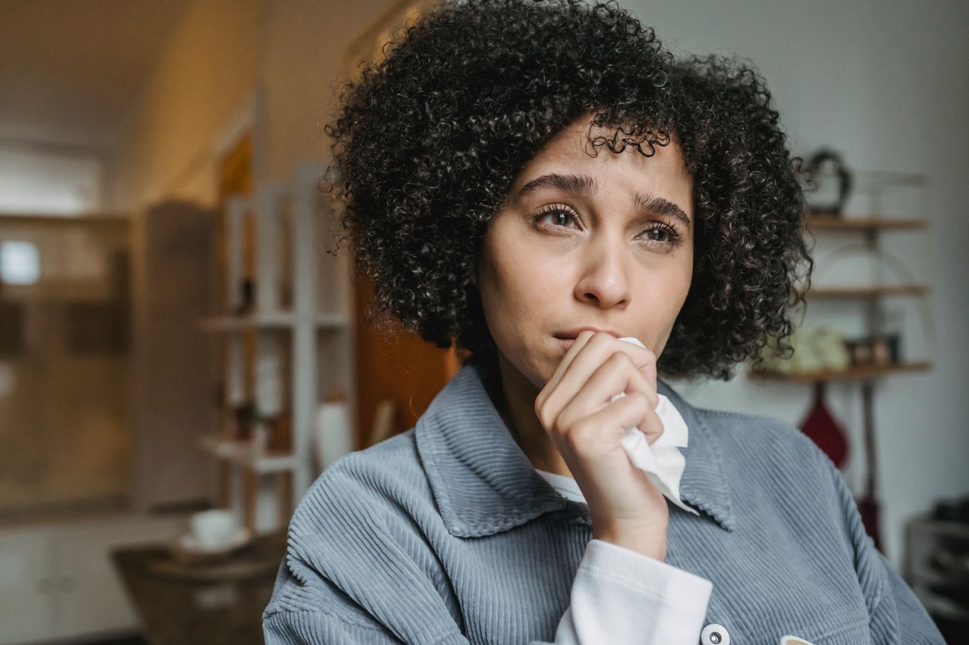 Psicólogo especialista en gestión emocional en Vigo Mujer con emoción contenida sentada en su casa