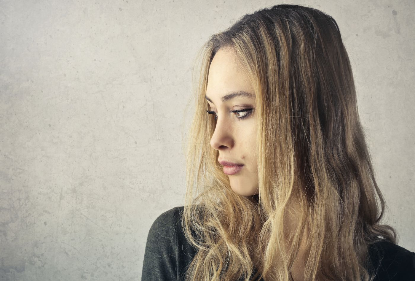 Psicólogo especialista en pensamientos obsesivos en Vigo Mujer pensativa con la mirada baja mientras aparecen pensamientos repetitivos